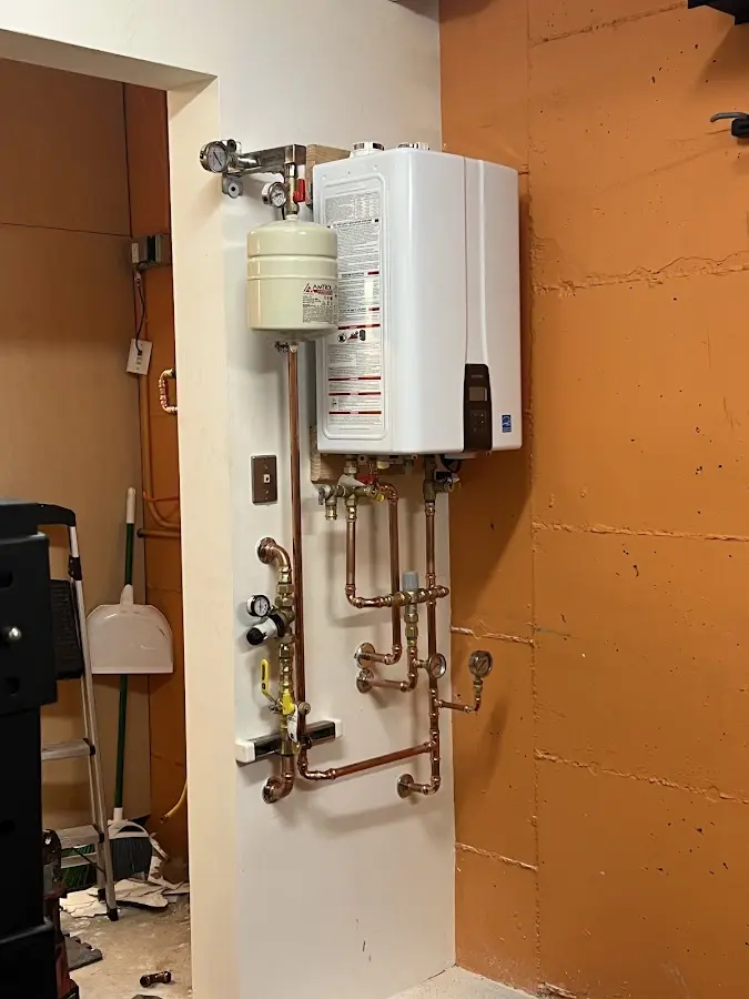 Plumbing technician inspecting water heater connections in Oak Hill